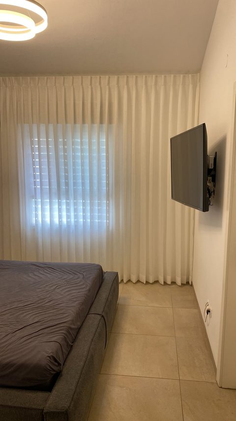 חדר שינה — וילון מקיר לקיר בגוון שמנת